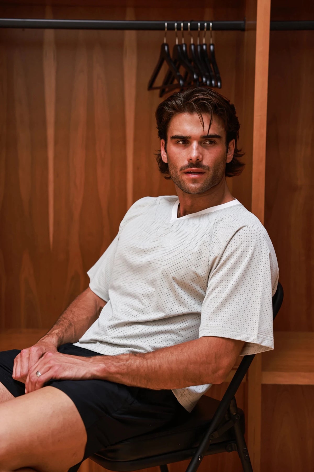 Bone-colored PODIO boxy semi-cropped training tee with short sleeves and relaxed fit, displayed on a hanger.